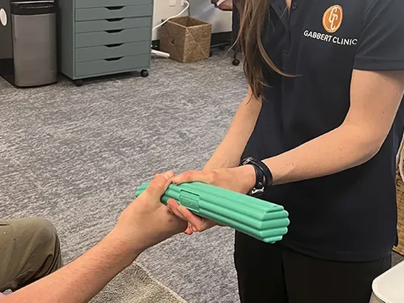Occupational therapist guiding a patient through an active resistance bar exercise
