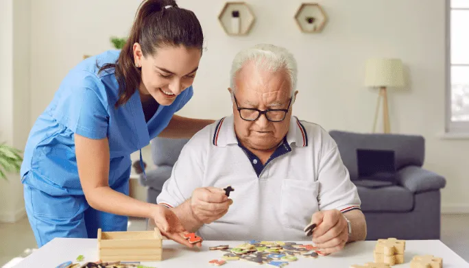 Clinician guiding an older patient through a tabletop puzzle exercise