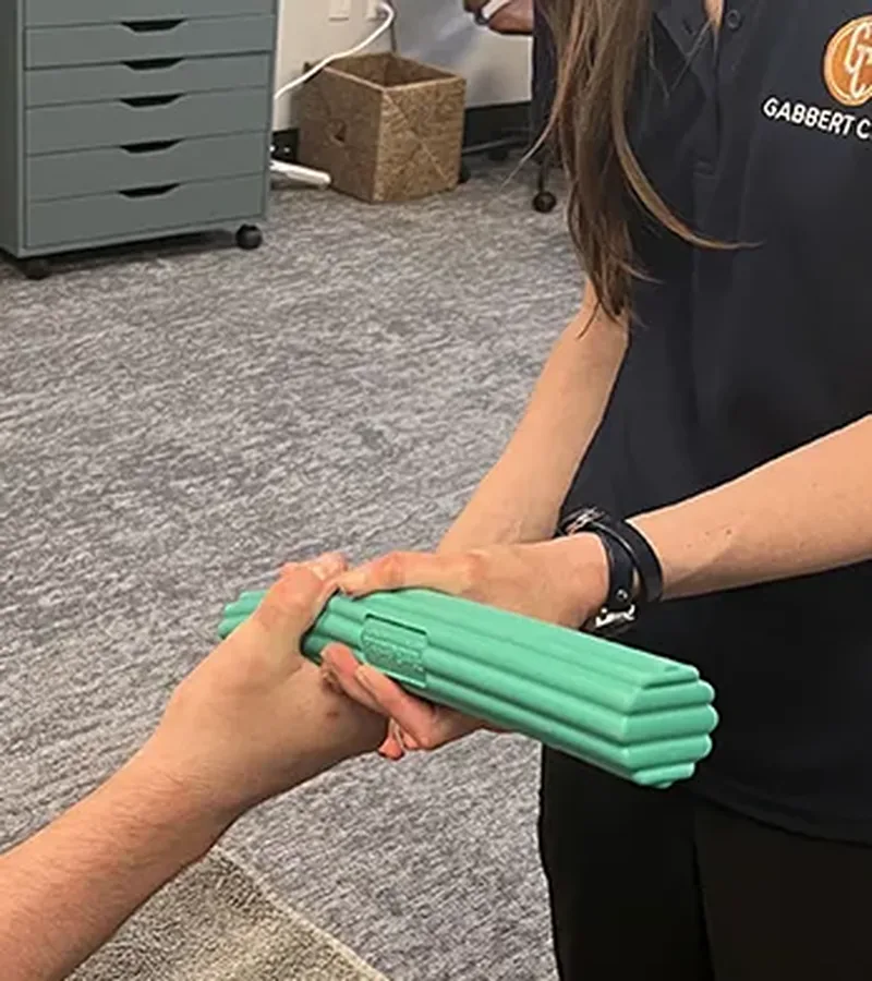 Occupational therapist guiding a patient through a resistance putty exercise