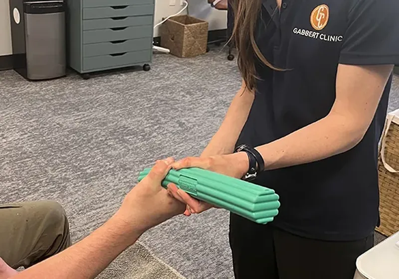 Occupational therapist guiding a patient through a resistance putty exercise