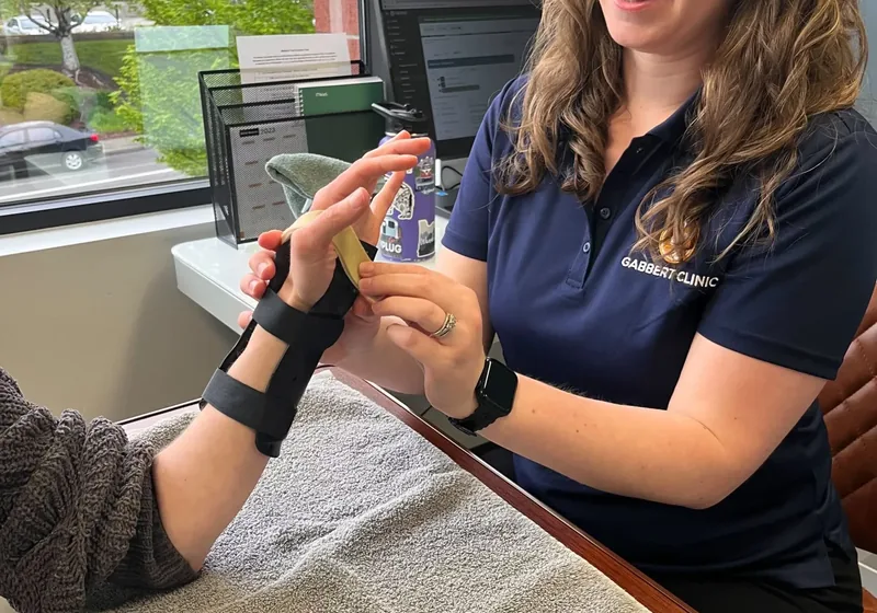 Therapist supporting a patient wearing a custom wrist orthosis